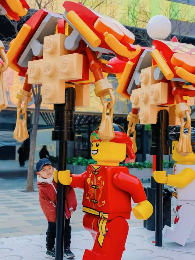 Walking with kids and taking photos with a strong festive atmosphere at the LEGO Carnival in Sanlitun, celebrating the Chinese New Year