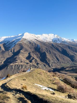 Crown Range Summit — ถนนบนภูเขาที่วิวเปลี่ยนโลก

ระหว่างทางบน Crown Range Road จากฝั่ง Queenstown มุ่งหน้าไป Wānaka มีจุดหนึ่งที่ทำให้ต้องหยุดรถแล้วมองอยู่นานกว่าปกติ — Crown Range Summit จุดชมวิวบนเส้นทางภูเขาที่พาดผ่าน Crown Range และเป็นหนึ่งในเส้นทางถนนที่สูงที่สุดของนิวซีแลนด์ 

วันที่ไป ทิวทัศน์ตรงหน้าสวยแบบไม่ต้องแต่งอะไรเพิ่มเลย ด้านหนึ่งเป็นภูเขาสีน้ำตาลทองของ Central Otago ตัดกับยอดเขาที่ปกคลุมด้วยหิมะ ส่วนอีกช่วงของเส้นทางกลับกลายเป็นโลกสีขาว เมื่อหิมะปกคลุมภูเขาและพื้นทางเดินจนแทบมองไม่เห็นสีของพื้นดิน

สิ่งที่ชอบมากคือ บรรยากาศเปลี่ยนไปตามระดับความสูงและสภาพอากาศ จากภูเขาแห้ง ๆ และทุ่งหญ้าสีทอง ค่อย ๆ กลายเป็นภูมิประเทศแบบอัลไพน์ที่มีหิมะปกคลุม ยิ่งวันที่ฟ้าเปิด สีฟ้าของท้องฟ้าก็ตัดกับภูเขาได้อย่างชัดเจน

บริเวณ Crown Range Summit ยังมีเส้นทางเดินขึ้นสู่พื้นที่สูงของ Pisa Conservation Area สำหรับคนที่อยากชมวิวแบบใกล้ชิดมากขึ้น โดยจากบริเวณยอดสามารถมองเห็นภูมิประเทศกว้างไกลทั้งสองฝั่งของเทือกเขา 

สำหรับคนที่ขับรถผ่านระหว่าง Queenstown และ Wānaka ที่นี่จึงไม่ใช่แค่ “จุดแวะระหว่างทาง” แต่เป็นอีกหนึ่งช่วงเวลาที่ทำให้รู้สึกว่า นิวซีแลนด์มีภูมิประเทศที่เปลี่ยนไปได้ภายในไม่กี่นาที

📍 Crown Range Summit, Otago, New Zealand
📸 ภาพถ่ายจากต้นฉบับที่ถ่ายด้วยตัวเอง

#crownrange #newzealand #queenstown #wanaka #southisland
