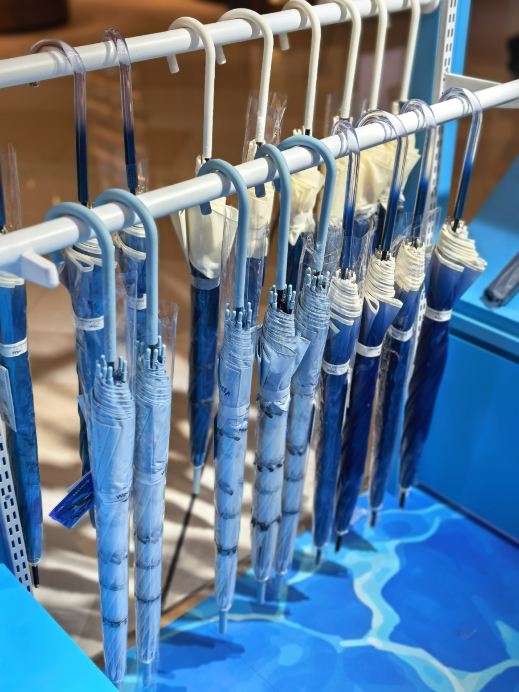 Wpc. umbrellas displayed on blue racks at a reported Shanghai iapm pop-up