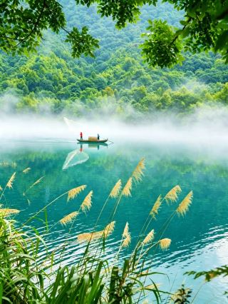 Boating on the emerald waves, people travel within a painting
