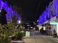 Artist city w colorful lights illuminating old buildings 