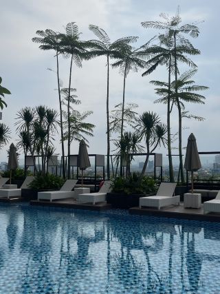 โรงแรม Aloft Surabaya Pakuwon City ยกระดับฝั่งตะวันออกของสุราบายา ทำให้ย่านมุลโยเรโจกลายเป็นจุดหมายปลายทางยอดนิยมสำหรับนักเดินทางในเมือง! 🏙️ โรงแรมทันสมัยแห่งนี้โดดเด่นด้วยทำเลที่ตั้งเชิงกลยุทธ์ เพียงไม่กี่ก้าวจากห้างสรรพสินค้า Pakuwon City Mall ทำให้การช้อปปิ้งและรับประทานอาหารสะดวกสบายอยู่เสมอ ในฐานะโรงแรมเปิดใหม่ Aloft นำเสนอบรรยากาศสดใหม่และสิ่งอำนวยความสะดวกชั้นยอดที่โดดเด่นทั้งด้านความสะดวกสบายและสไตล์

โรงแรมตั้งอยู่บนถนน Jalan Kejawan Putih Mutiara หมายเลข 8 เดินทางสะดวกด้วยถนนสายหลักหรือแท็กซี่จากสะพานสุรามดู สถาปัตยกรรมร่วมสมัยที่เรียบหรูโดดเด่นด้วยล็อบบี้ที่สว่างสดใสต้อนรับคุณ และห้องพักมีการออกแบบที่ชาญฉลาดด้วยหน้าต่างบานใหญ่ เหมาะอย่างยิ่งสำหรับการชมวิวเมืองในวันที่ฝนตกหรือต้นมะพร้าวเขียวชอุ่มด้านนอก 📸

อาหารเช้าได้รับคำชมอย่างมาก มีให้เลือกมากมาย ตั้งแต่อาหารท้องถิ่นไปจนถึงอาหารนานาชาติยอดนิยม เสิร์ฟในห้องอาหารโปร่งสบายที่ตกแต่งอย่างมีสไตล์ เลือกนั่งพักผ่อนกลางแจ้งริมสระว่ายน้ำเพื่อเริ่มต้นวันใหม่ด้วยความผ่อนคลาย แม้ในเช้าวันที่มีเมฆมาก บรรยากาศก็ยังสดชื่นเหมือนอยู่ในเขตร้อน สระว่ายน้ำเองก็สวยงามเหมาะแก่การถ่ายรูป ล้อมรอบด้วยต้นปาล์มและต้นมะพร้าว ทำให้ได้ภาพถ่ายที่ยอดเยี่ยมโดยเฉพาะในวันที่ฝนตกปรอยๆ เมื่อแสงสะท้อนบนผิวน้ำสวยงาม 🌴

เคล็ดลับส่วนตัว: ขอห้องพักที่หันออกไปด้านนอกเพื่อชมวิวเมืองที่ทันสมัยและบริเวณสระว่ายน้ำที่คึกคักได้ดีที่สุด สำหรับคนที่ตื่นเช้าควรลงไปทานอาหารเช้าทันทีเพื่อจะได้ที่นั่งริมสระว่ายน้ำกลางแจ้งที่อากาศถ่ายเทสะดวก

การจองง่ายและปลอดภัยที่สุดบน trip.com—คอยติดตามโปรโมชั่นโรงแรมใหม่ๆ! อย่ารีบร้อน ใช้เวลาสักสองสามชั่วโมงพักผ่อนริมสระว่ายน้ำ จากนั้นเดินไปช้อปปิ้งและหาของกินที่ห้างสรรพสินค้า Pakuwon City Mall #Surabaya #Mulyorejo #HotelReview #AloftSurabaya #CityBreak #TravelTips