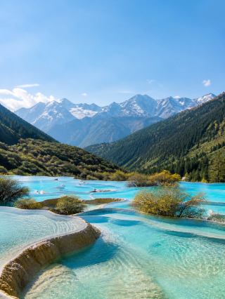 🇨🇳 Huanglong is the kind of place where the water looks edited before anyone touches the photo.