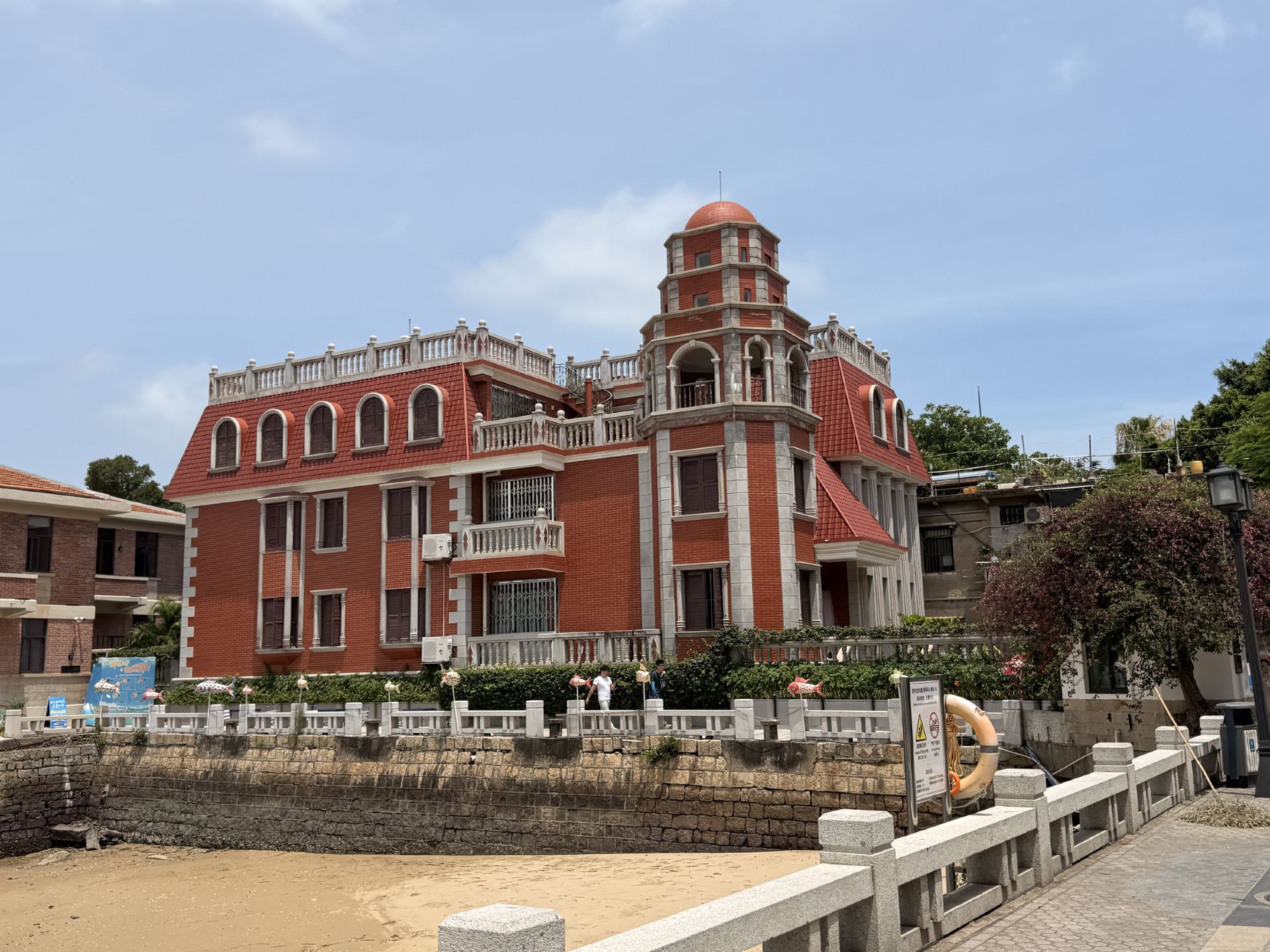 Before visiting Gulangyu Island, I read many travel guides. Some said you had to check out the most beautiful corner, others recommended various trendy cafes. But after actually setting foot on the island, I realized that what I enjoyed most was the leisurely stroll.

Starting from Sanqiutian Wharf, red-brick Western-style buildings, century-old villas, and winding alleys stretch out, offering different scenery at every turn. Gulangyu is similar to Tamsui in Taiwan, but with a touch of Southeast Asian and European colonial influence. The red-tiled roofs paired with tropical plants give the island a secluded and leisurely feel.

I almost gave up when I reached the foot of Sunlight Rock; it was very hot, and the stairs were steep. But since I was already there, I decided to climb. Reaching the top made it all worthwhile. The entire red-tiled rooftop of Gulangyu, the distant skyscrapers of Xiamen, the coastline, and the beaches unfolded before my eyes. Standing at this height, I truly understood why this place is a World Heritage Site.

What amazed me most was the view from the summit. Below me lay the old town, a blend of century-old Western-style buildings and lush greenery, while in the distance stretched Xiamen's modern skyline. History and modernity faced each other across the sea, creating a truly unique scene.

After descending the mountain, I didn't rush through my itinerary, simply wandering around the island. I stopped to take photos whenever I saw an old villa, and sat down on a beach to enjoy the sea breeze. Gulangyu doesn't have many exciting attractions, but it's perfect for slowing down and experiencing the island's unique rhythm.

If you ask me if Gulangyu is worth visiting, I would say yes. Not because of the popular tourist spots, but because it allows you to temporarily forget about the journey and simply focus on enjoying the sea breeze, sunshine, and the scenery before you.

#Gulangyu #SunlightRock #XiamenTravel #IslandTravel #WorldCulturalHeritage #Seascape #GulangyuGuide