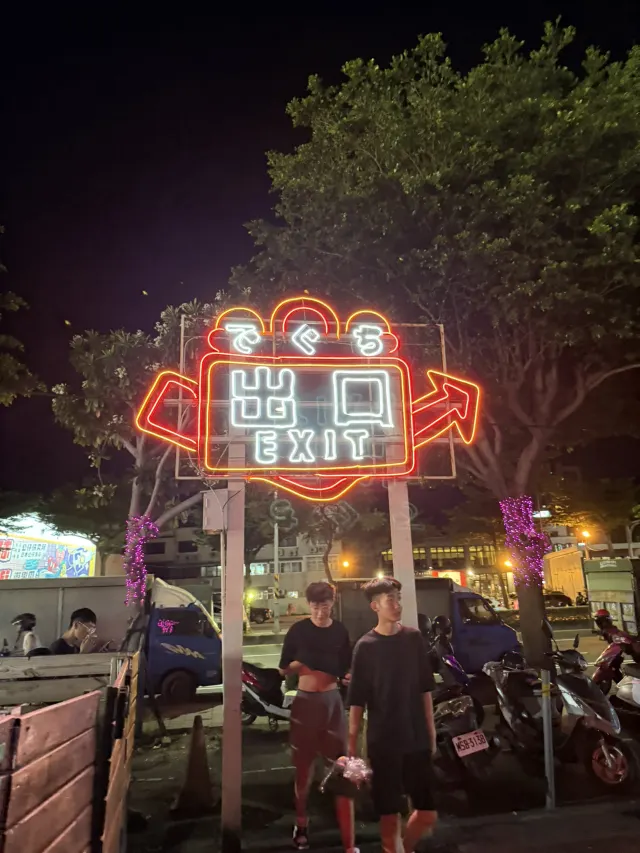 花園夜市出口的霓虹燈招牌，招牌上有出口與 EXIT 字樣及指示箭頭
