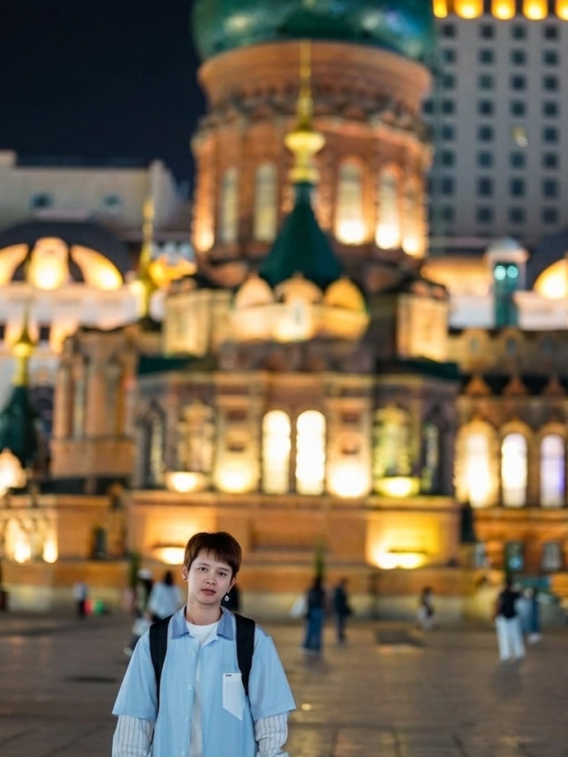  If you ask me which location in Harbin offers the most mesmerizing night photography, hands down, it has to be the Saint Sophia Cathedral, a legendary and breathtaking Byzantine-style architecture. Once night falls, the glowing golden lights beautifully contrast with the green domes against the pitch-black sky. All I can say is, 'It's so stunning, it feels like stepping right into ancient Europe.' 🏰🌟 
  You get to witness the sheer grandeur of the cathedral up close, beautifully juxtaposed against the modern buildings in the background. Step a little closer to capture the intricate details of the stained glass windows and carved motifs. Trust me, it's incredibly cool and classic. 
 If you're planning a trip to Harbin, I highly recommend visiting in the early evening. The lighting is absolutely perfect, and with the crisp, cool weather, you'll definitely have a blast strolling around and snapping photos.
     Self-guided