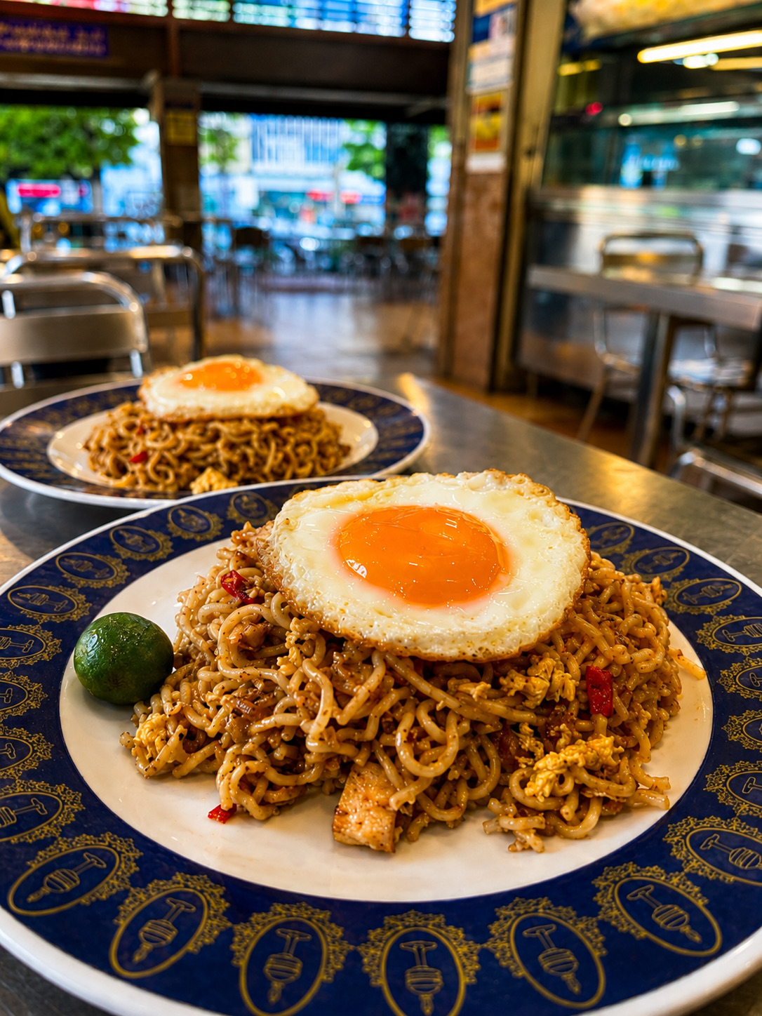Lagi cari makanan yang bikin nyaman di jam berapa pun?

Di Malaysia, ada satu tempat andalan warga lokal yang nggak pernah mengecewakan — restoran mamak.

Kebanyakan restoran mamak buka 24 jam, jadi pas banget buat sarapan, makan siang, makan malam, atau sekadar camilan larut malam setelah puas berkeliling kota.

Yang paling saya suka adalah pilihannya yang beragam banget. Kamu bisa menikmati:
· Nasi Lemak
· Roti Canai
· Mee Goreng Mamak
· Nasi Goreng
· Teh Tarik
· Maggi Goreng
Dan masih banyak lagi!

Harganya terjangkau, suasananya ramah, dan selalu ramai. Mau makan bareng teman, nonton bola, atau cuma lagi pengen makanan hangat, makan di restoran mamak selalu berasa seperti di rumah sendiri.

Buat saya, ini bukan cuma soal rasa makanannya, tapi soal suasananya. Duduk santai di ruang terbuka sambil menikmati segelas teh tarik dan sepiring roti canai adalah salah satu pengalaman paling autentik di Malaysia.

Kalau kamu ke Malaysia, menu mamak mana yang mau kamu coba duluan? Atau kalau kamu orang Malaysia, apa menu wajib yang selalu kamu pesan?