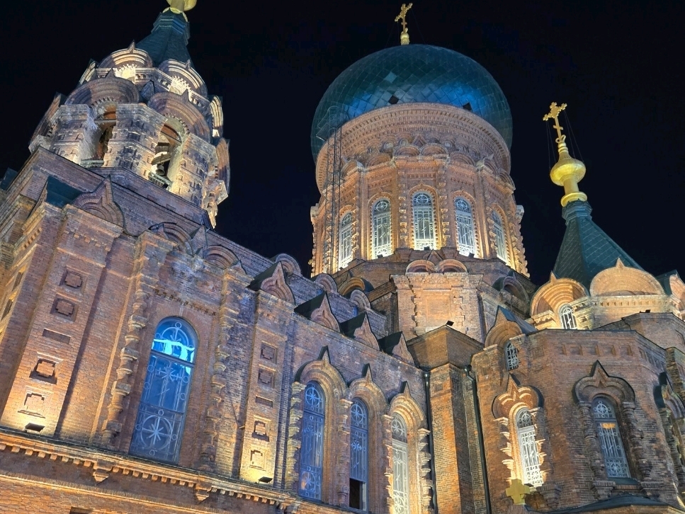 Harbin Attractions Guide: Hagia Sophia Night View + Authentic Food Recommendations
Hagia Sophia is a landmark Western-style building in Harbin, especially under the lights at night, the atmosphere is super romantic. The square in front of the church will gather many tourists, the atmosphere is full of photography, whether day or night is different feeling, it is recommended to come in the evening to take pictures, the lights illuminate the church brick walls and dome golden light, especially spectacular. Even if you don’t visit the church, it’s already a good feeling outside!

Recommended tour: After dinner itinerary
It is recommended to make a reservation for dinner nearby (such as the Authentic Iron Pot Stewed Goose Restaurant) and walk slowly over to Hagia Sophia. High crowds at night, be aware of safety and personal items. At night the church lights up after about 6:30, the square has the most photo angles, the front of the main entrance is the most popular photo spot!

Must-play items and photo spots
1. Hagia Sophia’s main entrance square: The architecture works best at night, and you can find different angles around to take pictures of the characteristic brick walls and domes.
2. Appreciate the details of the church’s exterior up close: The architectural details stand out under the light.
3. The square is crowded with people, and you can take pictures of the life scenes of local citizens and tourists, which has some special humanistic flavor.
4. There are occasional Russian-style snacks at nearby snack stalls.

Practical tips
1. It is recommended to visit between 6:30—9 pm, the most beautiful light and relatively safe.
2. Remember to bring a thick jacket in cold weather, Harbin at night temperature is lower.
3. Iron pot stewed goose restaurant portion is very large, southern friends suggested ordering a small portion, with potatoes taste great, but the amount is really not much.
4. Square photography It is recommended to use a wide-angle lens or mobile phone panorama function, the church appearance is spectacular enough.
5. There are sometimes musical performances outside the church.

Attraction Address: Toulong Street, Daoli District, Harbin City, close to Central Avenue, convenient transportation and walking distance.
Opening hours: The exterior of the church is open all day, with best lighting effects at night.

Precautions
Harbin winter outdoor temperature is low, remember to keep warm when walking at night; the large square is more open, the wind is stronger, it is recommended to wear a hat, gloves. It is recommended to stroll together in conjunction with Central Avenue and Songhua River area. If you have enough time, you can arrange a half-day route.

Concern topics: Harbin must-see, night view architecture, food recommendations, church architecture, humanistic scenery