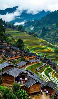 層層疊疊的田壟如天梯般蜿蜒山間，吊腳木樓隱現於雲霧中如仙境