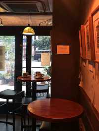 the café’s vintage wood-paneled interior, soft lighting, and jazz-infused ambiance create a warm🥰