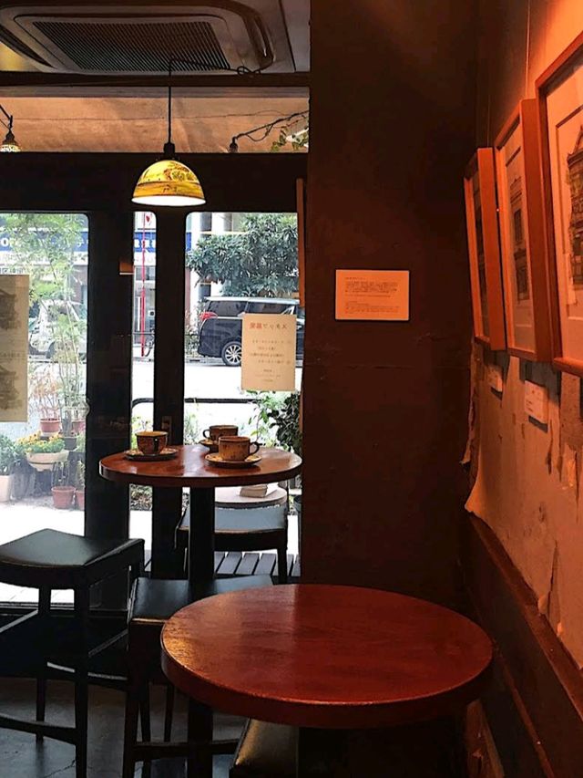 the café’s vintage wood-paneled interior, soft lighting, and jazz-infused ambiance create a warm🥰