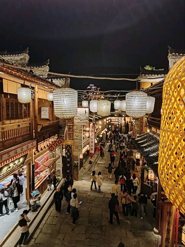 Wangxian Valley: Night Market Lights Reflecting Visitors