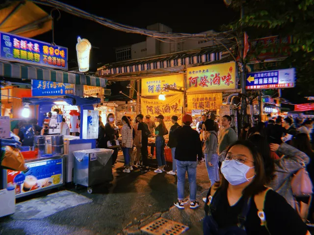 瑞豐夜市的攤位街景，招牌燈光下的走道人潮與各式小吃攤