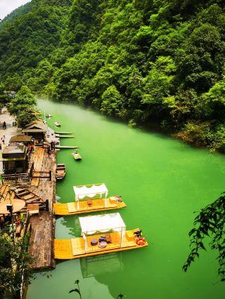 The small boat is like a leaf, floating on the continuous waves, carrying emotions in the green waters of the canyon