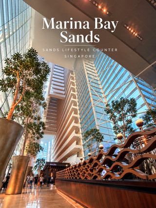 Sands Lifestyle Counter — Marina Bay Sands 🏙️⛴️
หนึ่งในภาพจำของสิงคโปร์ที่เห็นจนคุ้นตา คืออาคาร Marina Bay Sands ที่มีรูปทรงเหมือนเรือขนาดยักษ์พาดอยู่บนยอดตึกทั้งสามอาคาร
แต่พอได้เดินเข้ามาด้านใน กลับรู้สึกว่า ความสวยของที่นี่ไม่ได้มีแค่ด้านนอกเลย
บริเวณ Sands Lifestyle Counter และโถง Lobby มีสถาปัตยกรรมที่โดดเด่นมาก ทั้งเพดานสูงแบบโปร่ง กระจกขนาดใหญ่ที่เปิดรับแสงธรรมชาติ เส้นสายของโครงสร้างอาคาร และต้นไม้ขนาดใหญ่ที่นำเข้ามาเป็นส่วนหนึ่งของพื้นที่ ทำให้ Lobby ให้ความรู้สึกเหมือนเดินอยู่ในแกลเลอรีสถาปัตยกรรมขนาดยักษ์
สิ่งที่สะดุดตาเป็นพิเศษคือการใช้ ไม้ สีทอง และแสงไฟโทนอุ่น ตัดกับกระจกและโครงสร้างสีขาว ทำให้พื้นที่ที่มีขนาดใหญ่มากยังคงรู้สึกอบอุ่นและมีรายละเอียดให้มองอยู่ตลอดทาง
และเมื่อมองย้อนกลับไปถึงแนวคิดของตัวอาคารด้านนอก ก็ยิ่งน่าสนใจ เพราะรูปทรง “เรือ” ที่เป็นเอกลักษณ์ไม่ได้มีไว้เพียงเพื่อสร้างภาพจำของเมือง แต่เมื่อเข้ามาภายใน เราจะเห็นว่าทั้งพื้นที่ถูกออกแบบให้มีความต่อเนื่องระหว่าง สถาปัตยกรรม แสงธรรมชาติ และธรรมชาติ อย่างลงตัว
📸 สำหรับคนที่ชอบถ่ายภาพสถาปัตยกรรม แนะนำให้ลองเงยกล้องขึ้นมองเพดานและแนวกระจก จะได้มุมที่ต่างจากภาพ Marina Bay Sands แบบที่เราเห็นจากด้านนอกมากทีเดียว
ด้านนอกเป็นแลนด์มาร์กของสิงคโปร์
แต่ด้านในคืออีกหนึ่งมุมที่ทำให้เราเข้าใจว่าทำไมอาคารนี้ถึงโดดเด่นขนาดนี้
ภาพถ่ายจากต้นฉบับที่ถ่ายด้วยตัวเอง
#marinabaysands #singapore #architecture #sandslifestyle #เที่ยวสิงคโปร์