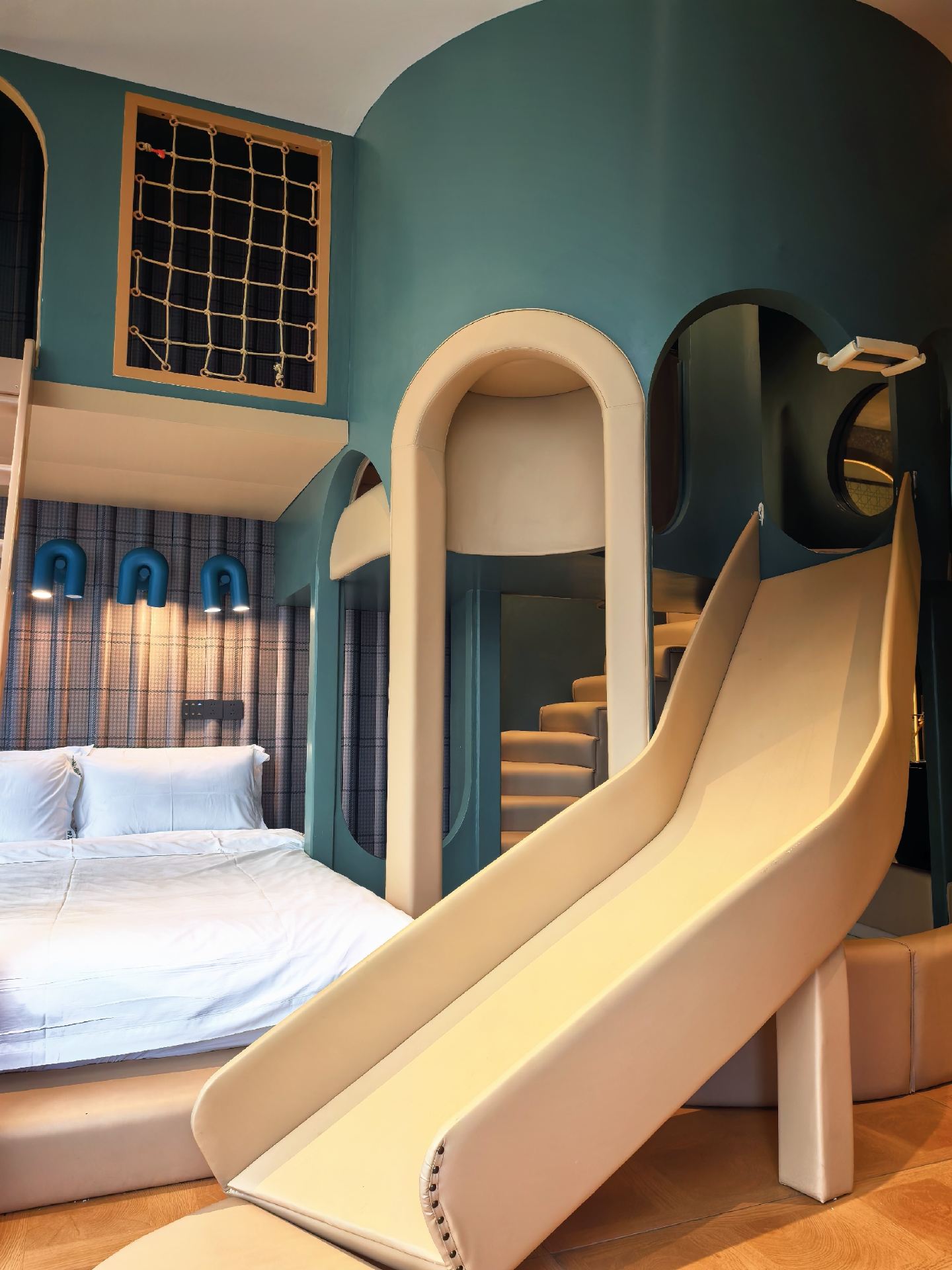 You won't believe it! This family room in the city center has brought a castle right into the room 🏰. Featuring a dark green cave castle design, arched doorways, secret tunnels, loft ladders, and a huge indoor slide. Kids won't want to leave once they enter—it's an immersive adventure that lets them burn off energy all day. Panoramic floor-to-ceiling windows overlook city skyscrapers, while the starry ceiling and atmospheric neon signs make every photo look like a high-end shot. The spacious layout with 2 large beds easily accommodates 2 adults and 2 children, and the bathroom features a premium bathtub. No need to rush to amusement parks; staying at the hotel is a trip in itself. 