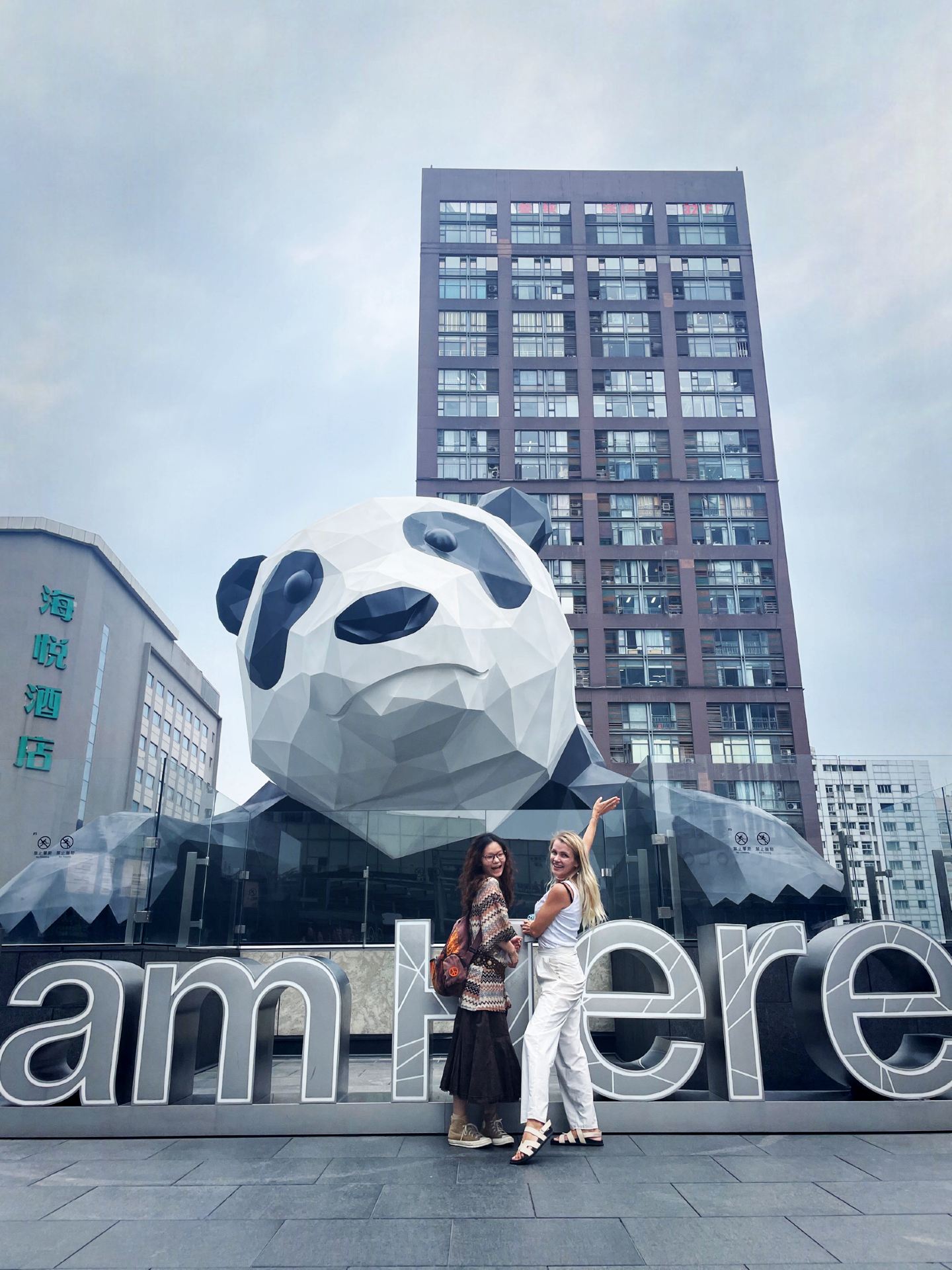 #photovsrealitytravel 

Everyone who visits Chengdu knows the iconic giant Panda sculpture hanging from the IFS Mall facade. You see thousands of tourists on the street below, pointing their cameras up at a massive, multi-ton furry butt dangling over the luxury boutiques.But here is the real insider secret that totally blew my mind: you can actually take an elevator up to the 7th-floor Roof Garden and stand right in front of her face!You get to look this legendary giant panda straight in the eyes and take a photo next to the famous artistic sign: "I Am Here." But if you want that perfect shot, you better be strategically prepared. Here is the raw truth about the world's most organized photo-op

 #hotdiscussion⏱️ The 2-Minute Creative SprintBecause this spot is a global Instagram and Douyin sensation, the local staff has turned content creation into a high-speed assembly line.

The System: The line moves with military precision. It doesn’t matter if it’s a boiling hot summer afternoon or a moody, pouring rain—hundreds of lifestyle bloggers and travelers stand in line, waiting for their turn.

The Rule: When you finally step onto the photo zone, your countdown begins. You have exactly 2 minutes. 120 seconds to drop your bags, strike your most confident high-fashion poses, check the lighting, and lock in the memories. The pressure is real, but the adrenaline makes the shots look so much more alive and spontaneous!

🏆 Why it's absolutely worth the waitIt might sound chaotic, but this strict organization is actually a blessing. It keeps the energy moving and ensures that every single person gets a clean, empty background without random strangers ruining the frame.

Standing on that rooftop, sandwiched between the soft green park and the hyper-futuristic glass skyscrapers of Chengdu, feels deeply individual and surreal. It’s an absolute masterpiece of modern urban design that leaves you laughing, energized, and holding a camera roll full of core memories.

Would you brave the rain and the clock for a face-to-face moment with the city's biggest icon? Let's discuss!