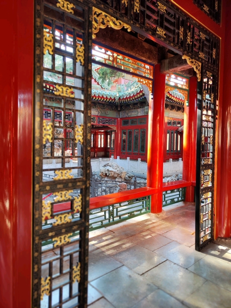 Upon entering the Ning Shou Palace Garden, one’s mind is instantly soothed, like a gentle breeze brushing past the ancient Chinese scholar tree. Transitioning from the grandeur of the Forbidden City's majestic halls, visitors are transported into a refined and poetic realm. This garden, built by Emperor Qianlong as a retreat for his retirement, encapsulates a miniature ideal world, perfectly blending imperial grandeur with the elegance of Jiangnan's scenic beauty.

The Gu Hua Pavilion derives its name from the ancient Chinese scholar tree standing in front of the courtyard. The tree's swaying shadows cast a dappled poetic charm, naturally slowing one's pace.

At the Xi Shang Pavilion, a clear winding stream flows through the meandering channel, evoking the ancient literati's elegant gatherings of "floating wine cups along the stream." The serene leisure and refined elegance of scholars seem to come alive, dispelling the solemn atmosphere within the palace walls, leaving only philosophical reflections and a deep appreciation for life.

The beauty of the Ning Shou Palace Garden is subtle and layered. The solemnity of red walls and golden tiles is cleverly concealed, replaced by a transcendent charm of "finding the essence of nature amidst the bustling city."

Here, a triumphant emperor, amidst the splendor of the palace, created a dreamlike landscape for himself. In this space, he is both the supreme ruler and a scholar yearning for transcendence and an elegant life. This garden is a dream he wove for himself in the twilight of a prosperous era, a dream of seclusion and poetic beauty.