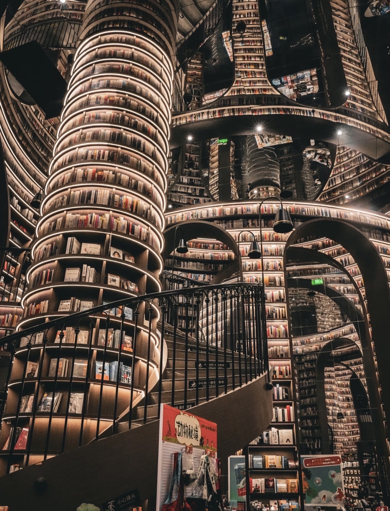 
Hey everyone! 👋 
Today I'm sharing a place that looks like an architect designed a cathedral for books. Zhongshuge isn't just a bookstore—it's a breathtaking labyrinth of mirrors, light, and sky-high shelves that make you want to stay forever. 📚✨

🏛️ The Rundown: A bookstore chain in China founded in 2013. The most famous spots are in Shanghai, Chengdu, Chongqing, and Beijing. Every store is a unique architectural masterpiece, looking straight out of a Christopher Nolan movie set. 

🌟 Why It's Magic

🪞 Mirrored Ceilings: In the Shanghai location, the ceilings are mirrors. The shelves stretch upward and reflect back, creating the illusion of an infinite library. 📖✨

🌀 Spiral Mazes: The Chengdu branch features winding mahogany tunnels connecting the halls. Getting lost here is all part of the fun. 🗺️

📚 Shelves to the Sky: Books cover every surface—walls, ceilings, and alcoves. Even if you aren't reading, just looking around feels surreal.

☕ Reading Nooks: Cozy corners with armchairs, coffee, and soft lighting. You can grab a book and settle in for the whole day. 📖

📍 Where to Find Them

· Shanghai — The most photogenic, featuring the mirrored ceiling
· Chengdu — The mahogany labyrinth
· Chongqing — A futuristic vibe with stunning lighting
· Beijing — Classic design, but equally impressive

Entry: Free. Coffee: Paid. 📸

💡 Pro Tips

· Arrive early ⏰ — Fewer crowds, better photos.
· Use a wide-angle lens 📱 — It’s the only way to truly capture the scale of the mirrors.
· Keep it down 🤫 — Remember, it’s still a library, not a theme park.
· Stay for a coffee ☕ — The atmosphere is pure therapy.

Drop a ❤️ and subscribe for more breathtaking destinations! 🌏✈️