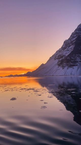 Captivating Canvas of Colors: Embark on a Serene Sailing Journey in Greenland and Witness the Unforgettable Beauty of a Majestic Sunset!