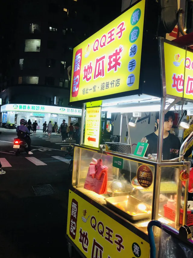 樂華夜市入夜後的攤位與走道,燈光明亮、機車與人潮交錯