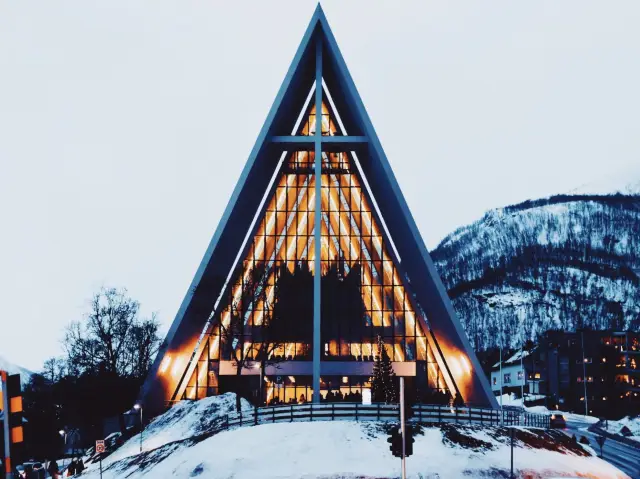 The shape of the white triangular snow mountain of the Arctic Cathedral resembles a towering iceberg in the clouds. 😇