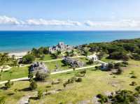 Ruins next to white sand beach 