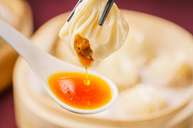 shanghai xiaolongbao on a spoon with broth