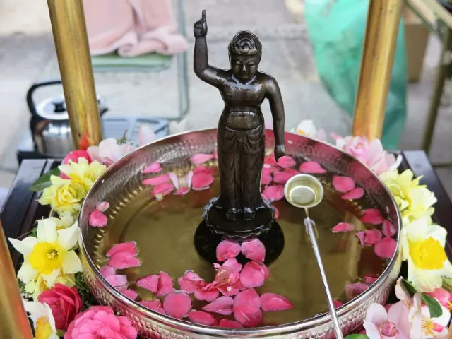 誕生仏に甘茶をそそぐ