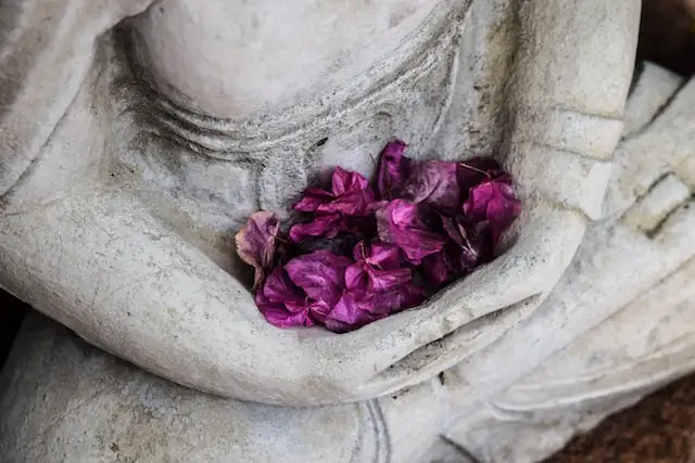 Flower offerings are placed on the statue of Buddha during the celebration of Buddha Purnima