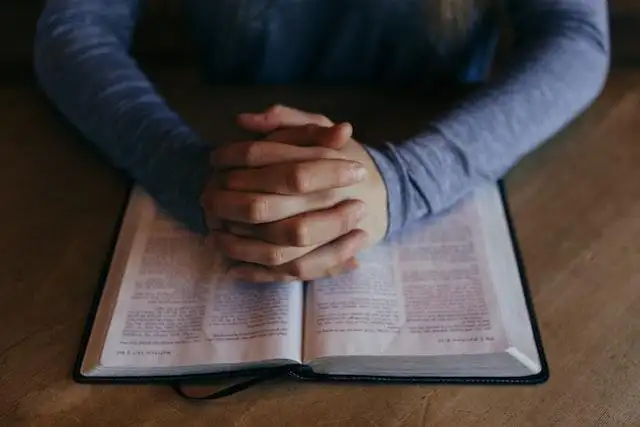 Good Friday 2024 - Person praying over a bible.