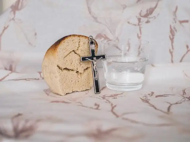 Good Friday 2024 - A portion of bread, a crucifix, and a glass of water for Lenten fasting