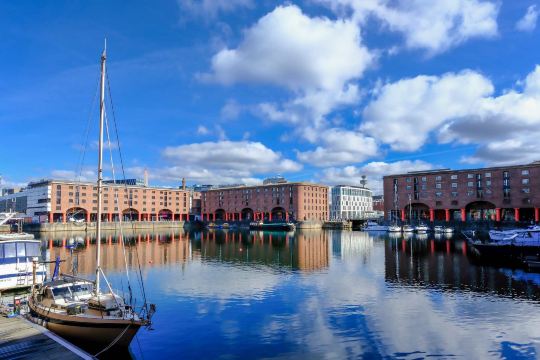Royal Albert Dock, Liverpool waterfront with historic warehouses and boats.