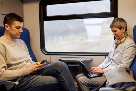 Passengers using devices on a train with WiFi.