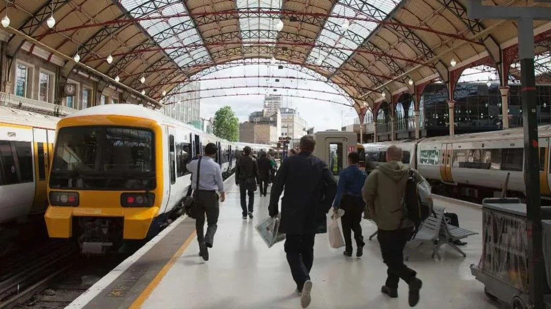 Passengers walking on a train station platform.