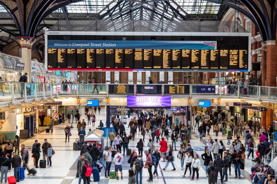 Busy Liverpool Street Station during peak train hours.