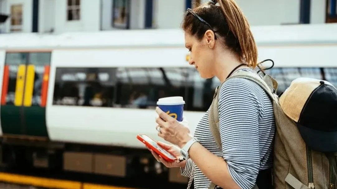 Passenger checks phone beside train