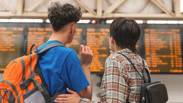 Passengers checking a train departure board