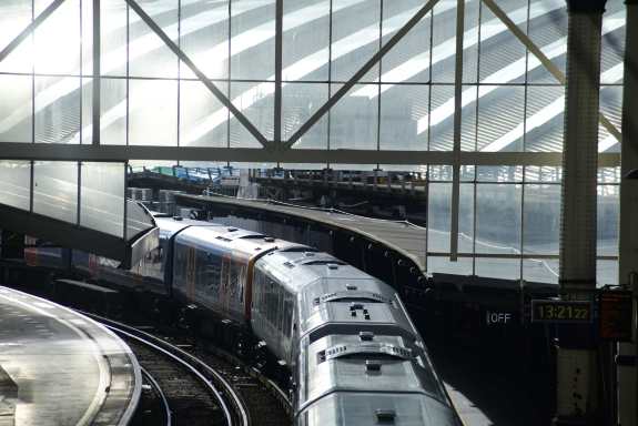 Train departing station in sunlight