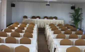 a conference room with rows of chairs arranged in a semicircle , and a podium at the front at Dynasty Hotel