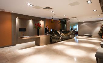 a modern office interior with marble floors , wooden furniture , and a man sitting at a desk at Clayton Hotel Chiswick