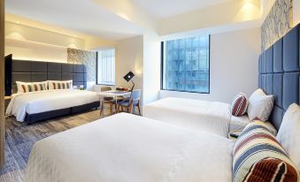 a modern hotel room with two beds , a window offering a view of the city , and various furnishings at Hotel Cham Cham - Taipei