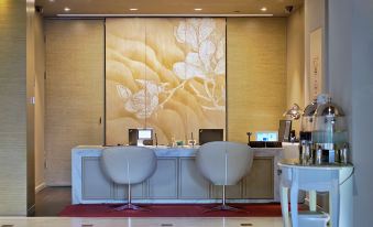 A room with chairs and tables in front, with an art deco design on the wall behind them at Jinjiang Metropolo Classiq Jing'An Hotel