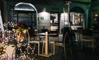 an outdoor dining area with tables and chairs , along with potted plants and flowers on the patio at Avenue Boutique Hotel
