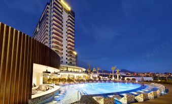 a large hotel with a swimming pool surrounded by lounge chairs and umbrellas , providing a relaxing atmosphere at Hard Rock Hotel Tenerife