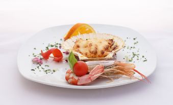 a white plate with a variety of food items , including shrimp , shrimp in shells , and an orange slice at Panorama Hotel