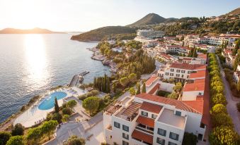 a picturesque view of a city by the sea with buildings , trees , and a swimming pool at Sun Gardens Dubrovnik