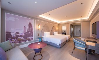 a modern hotel room with a large bed , couch , and table , as well as a city skyline mural on the wall at Hengxing Mercure Hotel