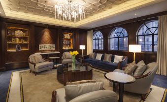 elegant and well-appointed living space featuring large windows, a chandelier, and tasteful furniture arranged in the center at Metropolo Xin Cheng Hotel, The Bund Shanghai
