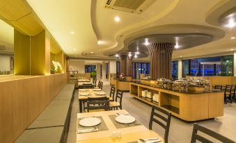 a modern , well - lit dining room with wooden tables and chairs arranged for a group of people at AVA SEA Resort Krabi